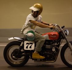 a man riding on the back of a red motorcycle