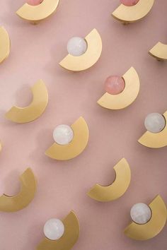 the wall is made up of yellow and pink shapes with white balls hanging from them