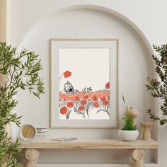 an art print on a wall above a shelf with potted plants in front of it