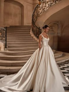 a woman in a wedding dress standing on stairs