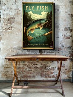 a fish poster hanging on the wall above a wooden table in front of a brick wall