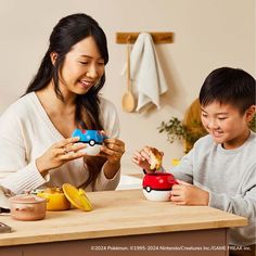 a woman and boy are sitting at a kitchen counter eating food from pokemon cars cups