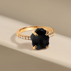 Our Ritzy Ring, adorned with potent Black Obsidian, is your faithful ally in times of need. Promoting strength and resilience, this ring will empower you to overcome life's toughest challenges. Acting as a protective shield, it also guards against stress and negative energies, making this the perfect stone for cleansing.
Details
- Genuine, untreated Raw Black Obsidian- White Zircon studded band- Stone Length: 0.31"-0.39" (8-10mm)- Stone Width: 0.28"-0.35" (7-9mm)- Stone Height: 0.26"-0.28" (6.5-7mm)- Cut: Raw & Untreated- Stone Weight: 5.05 ct- Metal Weight: 2.45 g- Gem authenticity approved by GIA Spiritual Obsidian Jewelry With Natural Stones, Black Obsidian Crystal Ring, Unique Black Obsidian Jewelry, Elegant Hand-strung Obsidian Jewelry, Black Obsidian Hand-strung Jewelry, Obsidian Ring, Raw Crystal Ring, Gem Diamonds, Black Obsidian