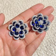 Sapphire Stud Earrings featuring semi precious navy blue stone with cz diamonds in a floral design. These PREMIUM QUALITY earrings can be apart from each others and you can wear these earrings in a multiple ways and create multiple looks. Perfect gift for her. *𝐏𝐑𝐎𝐃𝐔𝐂𝐓 𝐃𝐄𝐓𝐀𝐈𝐋* * 𝐌𝐚𝐭𝐞𝐫𝐢𝐚𝐥: Brass * 𝐏𝐥𝐚𝐭𝐢𝐧𝐠: White Rhodium Plated * 𝐒𝐭𝐨𝐧𝐞: AAA-quality CZ Diamond, Sapphire. *𝐃𝐈𝐌𝐄𝐍𝐒𝐈𝐎𝐍𝐒* * 𝐖𝐞𝐢𝐠𝐡𝐭: 8 gm each * 𝐋𝐞𝐧𝐠𝐭𝐡: 1.15 Inches * 𝐖𝐢𝐝𝐭𝐡:  1.15 Inches * 𝐂𝐥𝐨𝐬𝐮𝐫𝐞: Push Back 𝐕𝐢𝐬𝐢𝐭 𝐎𝐮𝐫 𝐅𝐀𝐐𝐬 𝐟𝐨𝐫 𝐒𝐡𝐢𝐩𝐩𝐢𝐧𝐠 𝐏𝐨𝐥𝐢𝐜𝐢𝐞𝐬 𝐚𝐧𝐝 𝐂𝐚𝐫𝐞 𝐈𝐧𝐬𝐭𝐫𝐮𝐜𝐭𝐢𝐨𝐧 *𝐃𝐈𝐒𝐂𝐋𝐀𝐈𝐌𝐄𝐑* * Product color may slightly vary due to photographic lighting sources or your screen settings. * Stone color may vary slightly due to Blue Sapphire Earrings Studs, Blue Diamond Earrings With Sparkling Stones, Blue Flower-shaped Diamond Jewelry, Blue Flower Shaped Earrings For Formal Occasions, Blue Flower-shaped Formal Earrings, Blue Formal Flower-shaped Earrings, Formal Blue Flower-shaped Earrings, Blue Diamond Earrings For Party, Blue Sapphire Earrings With Sparkling Stones