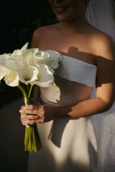 a bride holding a bouquet of white flowers