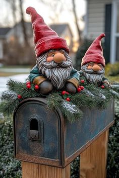 two gnomes sitting on top of a mailbox