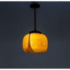 a yellow glass light hanging from a ceiling