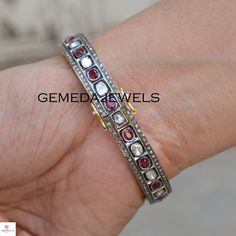 Polki Diamond Silver Bangle, Red Ruby Gemstone Bangle, 925 Sterling Silver Jewelry, Openable Bangle Bracelet, Wedding Gift, Gift For her Gross Weight: 29.59 gram Gemstone Weight: 8.91 cts Polki Diamond Weight: 1.52 cts Pave Diamond Weight: 2.44 cts Bangle Size: 63X63 MM NOTE:- All The Products Are Designed And Manufactured In My Workshop By Me & My Team. Shown Products Are Purely Handmade. Custom Orders Are Open Handly Accepted. We Are Perfect Choice For Any Custom Jewelry Manufacturing. For Silver Gemstone Bracelet For Anniversary, Silver Gemstone Bracelets For Anniversary, Anniversary Silver Bracelet With Gemstones, Silver Bracelets With Stone Setting For Anniversary, White Gold Bangle With 17 Jewels As Gift, Oval Hand Set Bangle For Anniversary, Hand Set Round Bracelets For Anniversary, Hand Set Bangle Bracelet For Anniversary, Hand-set Bangle Bracelet For Anniversary