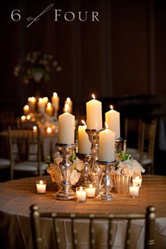 a table topped with lots of white candles