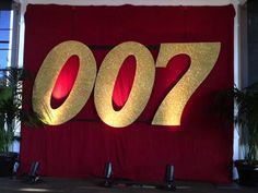 there is a red and gold sign that says 007 on the wall next to potted plants