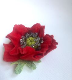 a red flower sitting on top of a white table