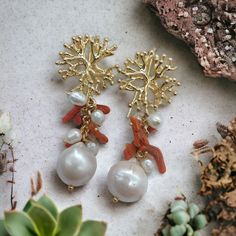 Wonderful marine themed earrings, with baroque pearl and natural red coral. The final pendant is a beautiful white baroque pearl, very bright, topped with freshwater pearls and natural red coral branches, mounted in a cluster style, on a gold-plated brass chain. The lobe attachment is coral-shaped, made of gold-plated brass and an open hook back closure. Total measurement length about 6 cm (2.30 Inch) Measure pearl width about 1.5 cm (0.60 Inch) For other similar articles click here https://www. Handmade Coral Earrings For Gifts, Handmade Baroque Pearl Drop Earrings, Coral Dangle Jewelry For Gifts, Elegant White Red Coral Jewelry, Handmade Coral Drop Earrings, Coral Pearl Drop Jewelry Gift, Coral Pearl Jewelry Gift, Coral Pearl Drop Jewelry As Gift, Handmade Red Coral Dangle Jewelry