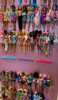 there are many barbie dolls lined up on the wall