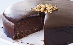 a chocolate cake with walnuts on top and one slice cut out from the cake