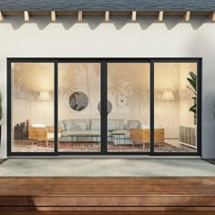 an open living room with sliding glass doors and potted plants on the outside patio