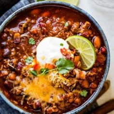 a bowl filled with chili and topped with sour cream