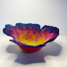 a colorful bowl sitting on top of a white table