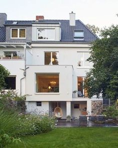 a large white house sitting on top of a lush green field