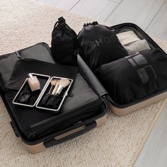 two pieces of luggage sitting on top of a rug