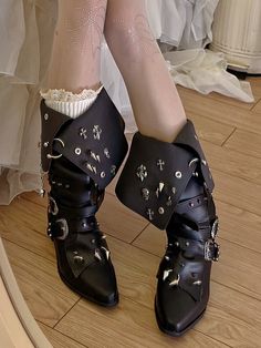 Step into a world of gothic elegance with these striking pointed-toe boots. Featuring a unique fold-over design adorned with skeleton and cross stud embellishments, these boots are a true statement piece. The addition of chain decorations adds an edgy flair, while the upper is further enhanced with stud details. For a personalized fit and style, adjustable buckle straps are included, ensuring both comfort and a perfect fit. Embrace your dark side with these intricately designed boots that blend Trad Goth Shoes, Winged Boots, Gothic Ballerina, Fantasy Boots, Gothic Heels, Chain Decorations, Armor Boots, Boots With Heels, Embrace Your Dark Side