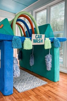 an inflatable car wash station is on the floor next to a rug with pom poms