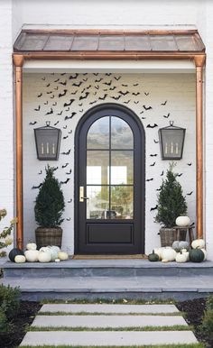 a front door decorated for halloween with bats and pumpkins