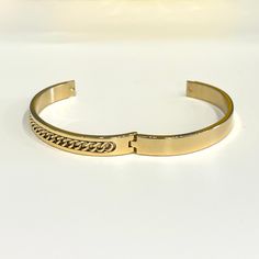 Bring home this magnificent bangle bracelet. Featuring a polished curb chain inlay design this bracelet is made from stainless steel. This is a seriously pretty bangle that is easy way to dress up any outfit, it makes a beautiful gift or a special treat for yourself.- Metal: Stainless Steel.- Plating: 18k Gold plated.- Inner Diameter: 64 mm.- Width: Aprox. 8 mm.- Clasp: Snap Closure.- Circumference Inches: 7.85 Ships in a Balara Gift Pouch.Available in Gold.SKU# B1781 Elegant Cuban Link Metal Bracelets, Tarnish Resistant Stainless Steel Cuff Bracelet, Stainless Steel Bangle With Adjustable Chain, Luxury Stainless Steel Cuff Bracelet, Tarnish Resistant, Gold Stainless Steel Bangle Bracelet, Luxury Metal Bangle Chain Bracelet, Trendy Stainless Steel Bangle Bracelet, Tarnish Resistant Metal Bangle Chain Bracelet, Chic Stainless Steel Bangle Jewelry