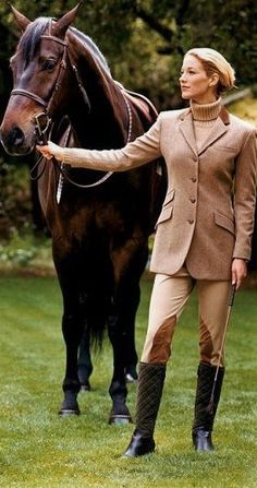 a woman standing next to a brown horse