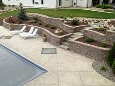 a backyard with a swimming pool and stone steps leading up to the side of the house