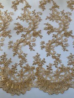 Melody GOLD Polyester Floral Embroidery with Sequins on Mesh Lace Fabric by the Yard for Gown, Wedding, Bridesmaid, Prom - 10002 Stand out magnificently as you gracefully appear wearing this stunning flowing fabric. Intricate embroidery adorns this fabric, with some sequins scattered all throughout, giving it a lavish and regal feel. Content: 100% polyester Stretch: Minimal to none Width: 50 to 52 inches Edge: Scalloped on both edges Uses: Wedding dress, evening gown, formal wear, tops, skirts, Lace Vail, Gold Lace Gown, Gold Lace Fabric, Tshirt Embroidery, Drawing Embroidery, Embroidery With Sequins, Shoes Embroidery, Embroidery Bracelet, Bracelet Embroidery