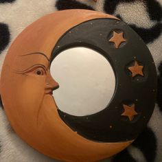 a crescent moon with a face and stars painted on it