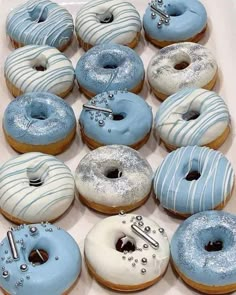 a box filled with blue and white donuts on top of a table next to each other