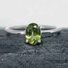 This ring is made from beautiful soft green Peridot which has beautiful sparkling lemony mint green hues. It is size 5.5. The rectangular faceted gemstone is 5 mm mm x 7 mm and is prong set in sterling silver.  Your sterling silver ring will be shipped gift boxed with a jewelry card listing gemstones and metal used. Classic Peridot Green Rings, Classic Green Peridot Ring, Green Faceted Ring For Anniversary, Green Peridot Birthstone Ring For May, Green Peridot Solitaire Birthstone Ring, Jewelry Card, Green Hues, Green Peridot, August Birth Stone