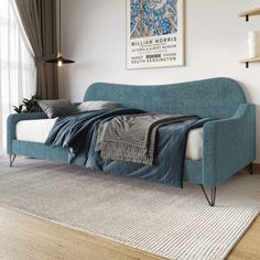 a blue couch sitting on top of a wooden floor next to a white rug in a living room