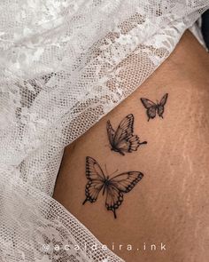 three butterflies on the side of a woman's stomach, one is black and white