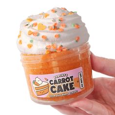 someone is holding up a cupcake shaped cake in a jar with whipped cream and sprinkles