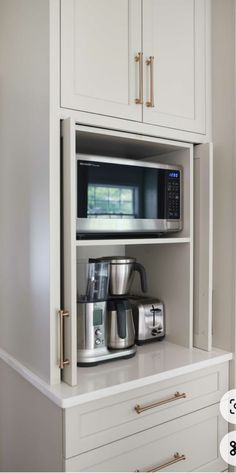 a microwave and coffee maker in a white cabinet