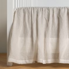 a white curtain hanging on the side of a wall next to a radiator