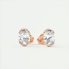 pair of rose gold earrings with round brilliant cut diamond in the center, on white background