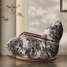 a black and white chair sitting on top of a wooden floor next to a window