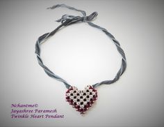 a heart shaped beaded necklace on a gray string