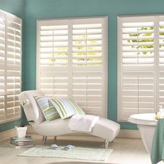 a bathroom with blue walls and white shutters