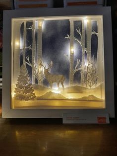 an illuminated paper cut deer in the woods