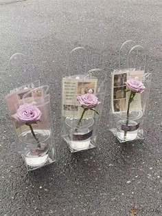 three clear vases with pink roses in them