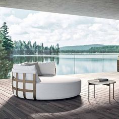 a couch sitting on top of a wooden floor next to a lake