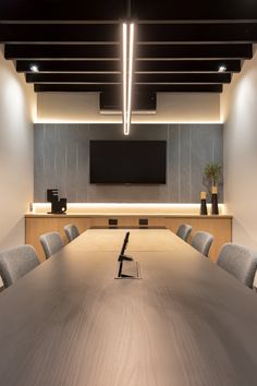 an empty conference room with chairs and a flat screen tv