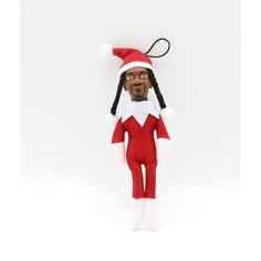 the elf doll is wearing a red and white outfit with black hair, his eyes are closed