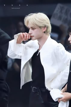 two young men standing next to each other wearing black and white outfits, one with blonde hair