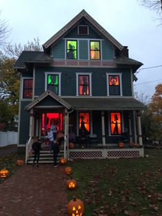 two people standing in front of a house decorated for halloween