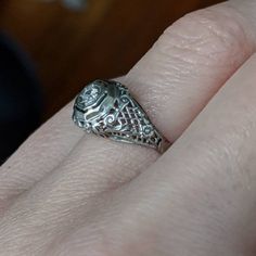 This Art Deco engagement ring has no shortage of charming details. Lacey, beaded scrolls and criss-cross patterns cover the whole top of the ring making it light and airy. It is crowned with a glittering diamond held in place by 8 tiny prongs. It would make an excellent engagement or vintage statement piece! * Art Deco 1930's approximately * 18K White gold * .07ct (approximate) Transitional cut diamond * Size 6.5 - Can be resized within a couple sizes * Very good/excellent condition - Some wear Antique Platinum Jewelry In White Gold, Classic White Gold Jewelry With Rose Cut Diamonds, Antique 14k White Gold Jewelry With Prong Setting, Victorian Platinum Filigree Jewelry, Heirloom Sterling Silver Diamond Ring, Antique Engraved White Gold Ring With Diamond Cut, Antique White Gold Engraved Ring With Diamond Cut, Antique 14k White Gold Round Cut Jewelry, Antique 14k White Gold Jewelry With Intricate Design